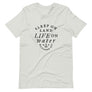 Ash colored unisex t-shirt with wording "Sleep on Land, Live on Water" written in black artistic lettering on front. Underneath this is very small semi circle stating "Mutineer Bay" centered with small anchor.