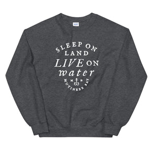 Grey unisex sweatshirt with wording in white, "Sleep on Land, Live on Water" written in black artistic lettering on front. Underneath this is very small semi circle stating "Mutineer Bay" centered with small anchor. All lettering and images are in white.